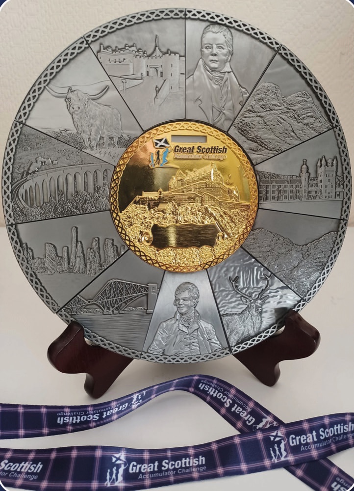 The Great Scottish Accumulator Challenge Medal on its stand, with the tartan ribbon