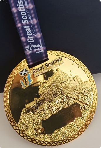 The gold central medal, featuring Edinburgh Castle, on the tartan ribbon