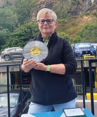 Petra Arndt with her Accumulator Challenge Medal below Edinburgh Castle