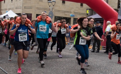 Runners carrying sacks of potatoes in the Great Perthshire Tattie Run