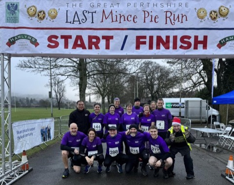A running club team at the Last Mince Pie Run start/finish gantry